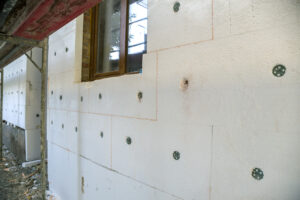 Insulation work of house walls with styrofoam sheets.